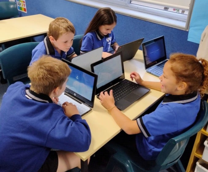 Image of four students using laptops.