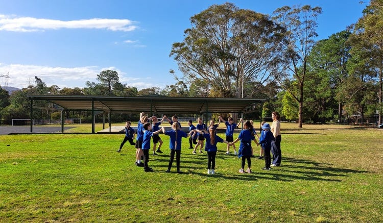 Students playing a running game with their teacher.